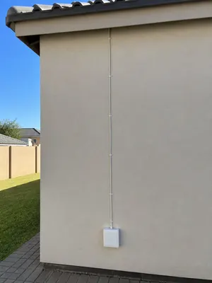 Tidy coaxial cable run and weatherproof junction box on a plastered exterior wall